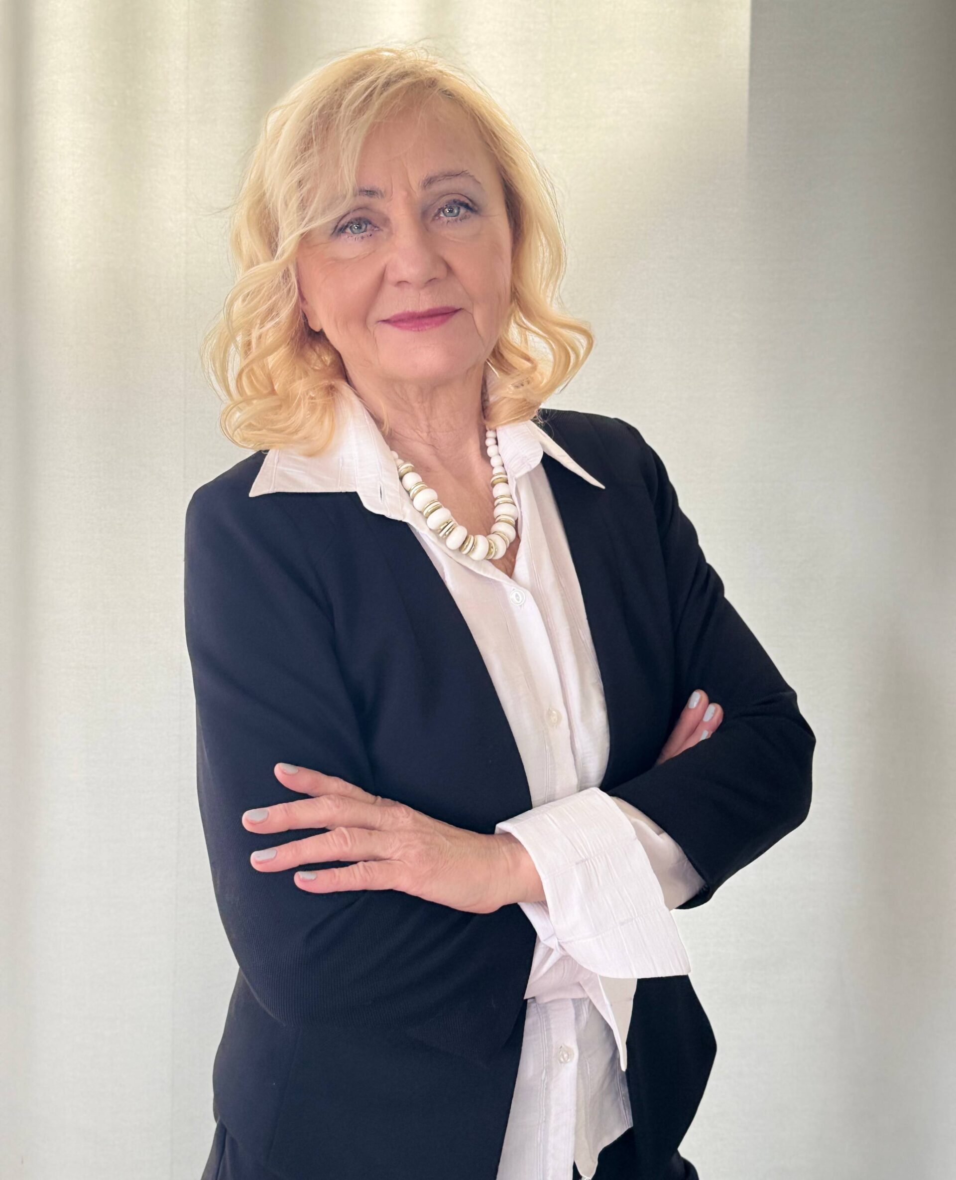 Małgorzata Jankowska-Stachow – elegancka kobieta w białej koszuli i czarnej marynarce na jasnym tle
